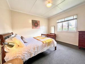 a bedroom with a bed and a window at Denham Cottage - Quart Pot Creek in Stanthorpe