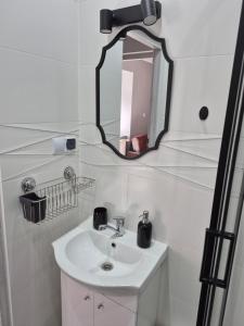 a white bathroom with a sink and a mirror at Apartament nad Włodzicą in Nowa Ruda +3 photos