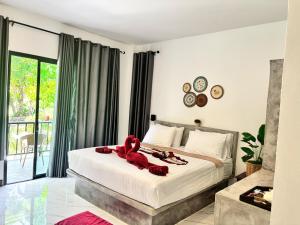 a bedroom with a bed with a red teddy bear on it at Lanta Buddy Resort in Ko Lanta