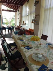 a long table with plates on it in a room at Bed & Breakfast Orizzonte in Castello di Brussa
