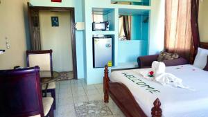 伯利兹城See Belize TRANQUIL SeaView Studio with Balcony, Pool, Deck Kitchenette 2nd FL的一间卧室，床上有一张牌子