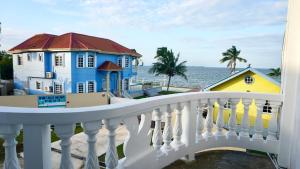 伯利兹城See Belize TRANQUIL SeaView Studio with Balcony, Pool, Deck Kitchenette 2nd FL的阳台享有房屋和大海的景致。