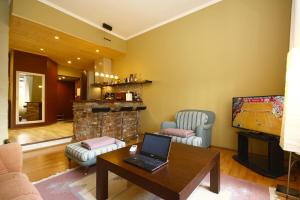 Sadama 11 Apartment في بارنو: غرفة معيشة مع لاب توب على طاولة وتلفزيون