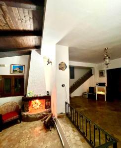 a living room with a fireplace and a staircase at Villa Taormina Sicily in Furci Siculo