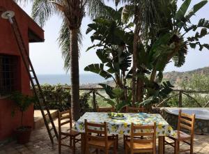 a table and chairs on a patio with the ocean at Villa Taormina Sicily in Furci Siculo