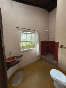 ein Badezimmer mit Waschbecken und Toilette und einem Fenster in der Unterkunft Ecocentro Brasil - Bangalô 5 in São Pedro + 18 Fotos