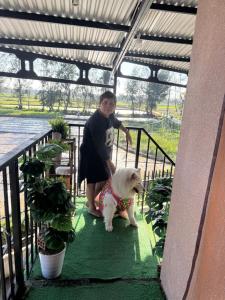 a woman standing next to a white dog on a staircase at Happy House TB in Thăng Bình