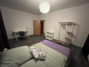 Un dormitorio con una cama, un escritorio y una mesa. en Lavendel Wohnung, en Duisburg