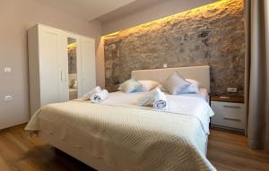 una camera con 2 letti con lenzuola bianche e cuscini blu di House Vidovic by Villas Guide a Mlinište