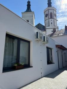 a white building with a clock tower in the background at Apartmány U Kostela in Uničov
