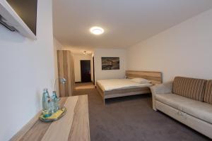 ein Wohnzimmer mit einem Sofa und einem Bett in der Unterkunft Hotel Stadt Tuttlingen in Tuttlingen