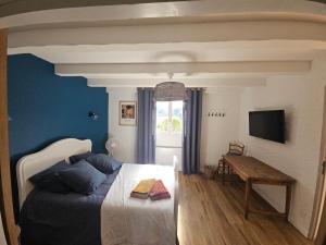 een slaapkamer met een bed, een tafel en een televisie bij Maison 3 chambres - Central - Proche du lac in Esparron-de-Verdon