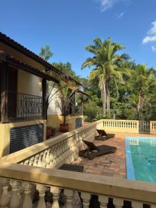 eine Villa mit Swimmingpool und ein Haus in der Unterkunft Ecocentro Brasil - Bangalô 5 in São Pedro