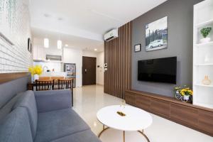 een woonkamer met een bank en een tv bij Dear You, Apartment! Saigon - Rivergate Building in Ho Chi Minh-stad