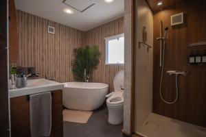 a bathroom with a tub and a toilet and a sink at Modern Container House - 2 Min Walk to Matsubara Beach - Sleeps 7 in Tsuruga +173 photos