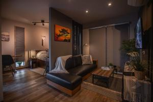 a living room with a leather couch and a bed at Modern Container House - 2 Min Walk to Matsubara Beach - Sleeps 7 in Tsuruga