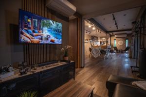a living room with a flat screen tv on a wall at Modern Container House - 2 Min Walk to Matsubara Beach - Sleeps 7 in Tsuruga