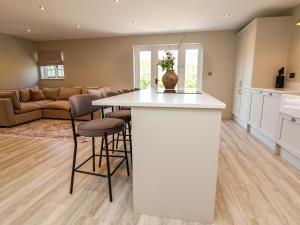 a kitchen and living room with a table and chairs at Egerton Cottage in Crewe