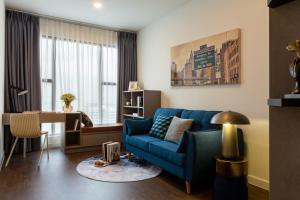 胡志明市Dear You, Apartment! Saigon - Rivergate Building的客厅里有一张蓝色的沙发和一张桌子