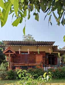 una casa de madera en un jardín en Far Far Away Homestay Chiangdao, en Ban Tham