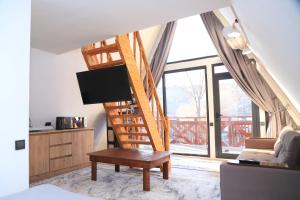 a living room with a spiral staircase with a tv at Алтын Балык in Toktogul