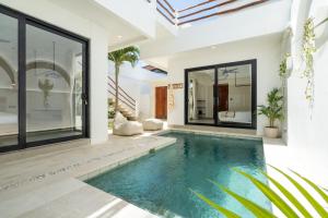 an indoor swimming pool in a villa at Villa Le Blanc - Tropical Luxury 3BR Villa with Pool & Rooftop Views in Tumbak Bayuh in Tumbak Bayuh +85 photos