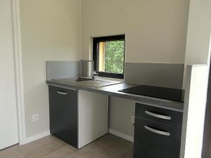 Domaine de l homme في Saint-Vincent-le-Paluel: مطبخ مع كونتر مع حوض ونافذة