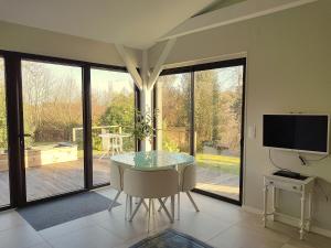 Domaine de l homme في Saint-Vincent-le-Paluel: غرفة طعام مع طاولة وكراسي وتلفزيون