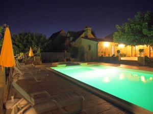 Domaine de l homme في Saint-Vincent-le-Paluel: مسبح في الليل مع كراسي ومظلات +6 صور