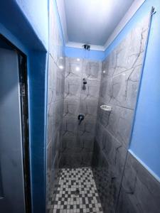 a bathroom with a shower with a tiled floor at Evergreen guest house in Pietermaritzburg