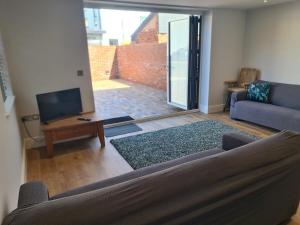 a living room with a couch and a television at Number 10 - Stunning brand new house - sleeps 6 - free parking in Topsham