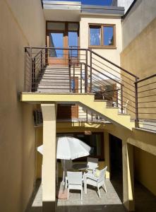 a house with a patio with a table and an umbrella at Alto Mare Apartments in Selce