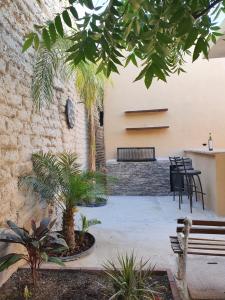 a courtyard with a bench and a table and chairs at Casa la Borgoña in Cuatrociénegas de Carranza