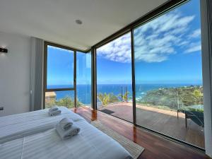 a bedroom with a bed and a view of the ocean at Villa Deluxe - Jardin del Mar y Cielo in Tacoronte
