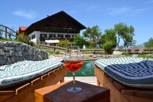 a glass of wine sitting on a table next to a pool at Bussjägerhof in Böbing