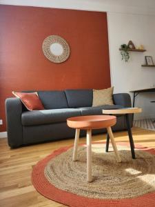 a living room with a blue couch and a stool at Studio Terre - 1st floor - City center - Train station 5 minutes away in Charleville-Mézières