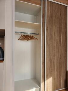 a white closet with some wooden hangers in it at Studio Terre - 1st floor - City center - Train station 5 minutes away in Charleville-Mézières +15 photos