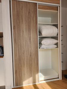 a closet with a wooden door and some towels at Studio Terre - 1st floor - City center - Train station 5 minutes away in Charleville-Mézières