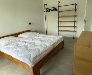 a bedroom with a bed with white sheets on it at Ferienwohnung Brandung - Haus Seeschwalbe in Schillig