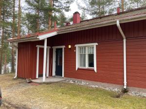 a red house with a white door and a window at Koli country club basic 6 in Hattusaari