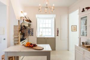 a kitchen with a table with a bowl of fruit on it at Central 3 Bedroom Apartment in Ericeira in Ericeira