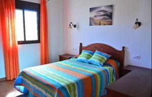 a bedroom with a bed with a colorful blanket and a window at Residencial La Teja in Zahora +37 photos