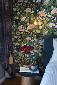 a bedroom with a floral wallpaper with a vase of flowers at The Oscar Olympic Hotel in Thessaloniki