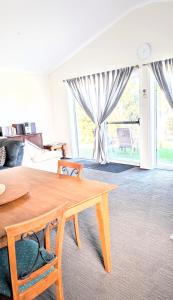 a living room with a wooden table and a couch at Hilltop Riverview Retreat in Clayton Bay