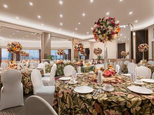 un salón de banquetes con mesas largas y sillas blancas en Hotel Kimberly Manila en Manila