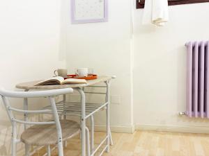 Holihome Le Orchidee في سان بنيديتّو ديل ترونتو: طاولة وكرسي مع كتاب عليهما في الغرفة