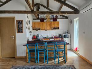 a kitchen with a island with blue stools at Balkan Barn in Tŭzha