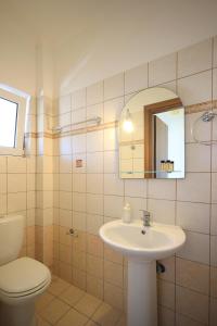 a bathroom with a sink and a toilet and a mirror at Bella Meliti in Lygia