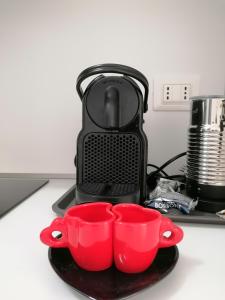 Quarto Inferioreにあるcasa Ileのコーヒーメーカーの横にある黒皿の赤いカップ2つ