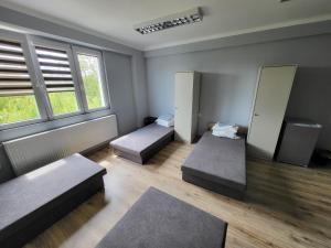 a room with three beds and two windows at Kwatery pracownicze Stalowa Wola Nisko in Nisko